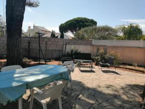 d'une terrasse avec une table, des chaises et une clôture. dans l'établissement Villa portiragnes, à Portiragnes