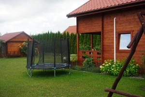 a trampoline in a yard next to a house at Domek letniskowy Orzech Rydzewo in Rydzewo