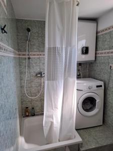 a shower curtain in a bathroom with a washing machine at TEODORA - kamenný domek 300 m od moře in Novalja