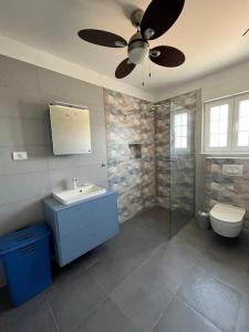 baño con lavabo y ventilador de techo en Family apartment Sevid, en Sevid