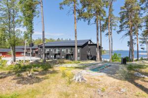uma casa negra com árvores em frente em Furuvik Havshotell 