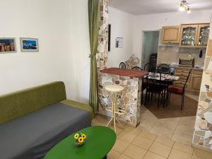 sala de estar y cocina con sofá y mesa en Francesco Apartmanház, en Velence