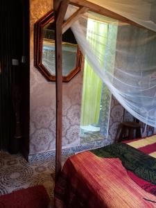 a bedroom with a canopy bed with a window at Sasana Motel and Guest House in Bungoma