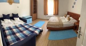 1 dormitorio con 2 camas y alfombras azules en Francesco Apartmanház, en Velence