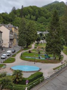 vistas a un parque con una fuente en una ciudad en Chez Ghys, en Eaux-Bonnes