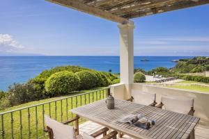 un patio con tavolo, sedie e vista sull'oceano di The Seasons a Svoronáta