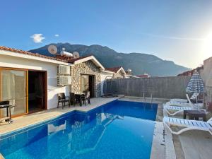 a villa with a swimming pool and mountains in the background at Likya Suit B 2+1 Villa, Özel Havuzlu, Fethiye in Fethiye