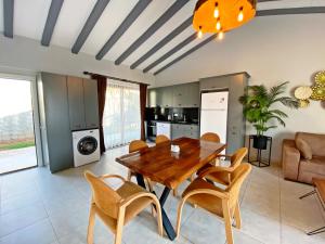 a kitchen and dining room with a wooden table and chairs at Likya Suit B 2+1 Villa, Özel Havuzlu, Fethiye in Fethiye