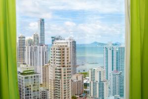 uitzicht op een stad met gebouwen en de oceaan bij Riu Plaza Panamá in Panama-Stad