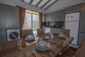 a kitchen with a dining room table with dishes on it at Likya Suit B 2+1 Villa, Özel Havuzlu, Fethiye in Fethiye +2 photos