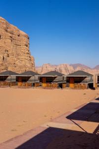 un bâtiment dans le désert avec des montagnes en arrière-plan dans l'établissement Salman Zwaidh Camp, à Wadi Rum