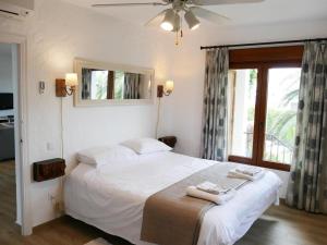 a bedroom with a white bed with a ceiling fan at REf 3 VILLA ISBILIA in Zahara de los Atunes +29 photos