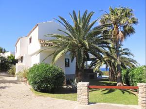 a house with two palm trees in front of it at REf 3 VILLA ISBILIA in Zahara de los Atunes