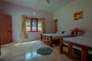 een woonkamer met 2 bedden en een raam bij Prakruthi Home Stay in Sollebail