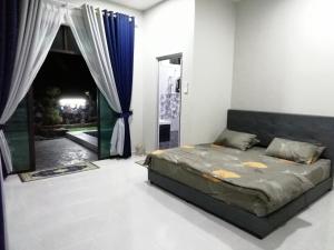 a bedroom with a bed and a large window at D'NKP Homestay Tanah Merah in Tanah Merah