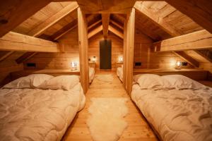 2 camas en una habitación con techos de madera en Chalet Beleza en La Salle Les Alpes