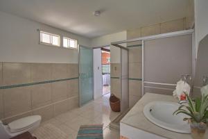 y baño con lavabo, ducha y aseo. en Sunni Pacha - Casa de Campo, en Pachacámac