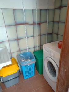 lavadero con lavadora y 2 cubos de basura en Casa S'Ozastro, en Marinella