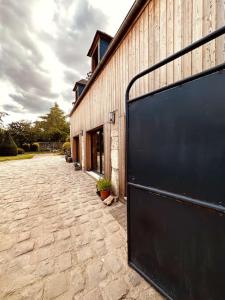 una puerta de garaje negra en el lateral de un edificio en La Cour Verte : Chaleureuse grange réhabilitée, en Montépilloy