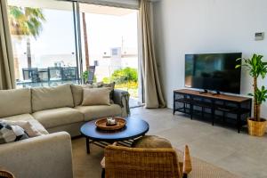 Il comprend un salon doté d'un canapé et d'une télévision à écran plat. dans l'établissement 4 Bed Residential Palm Beach Fuengirola, à Fuengirola