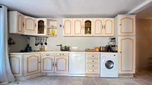 - une cuisine avec des placards blancs et un lave-linge dans l'établissement Appartement T2 - Saint-Blaise - Moderne, à Bollène