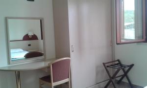 Istia dʼOmbroneにあるL'Oasi Residenceのベッドルーム(鏡、デスク、椅子付)