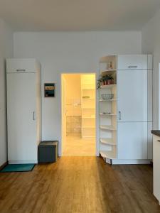 ein leeres Zimmer mit weißen Schränken und einem Flur in der Unterkunft Art Apartment Telč in Telč