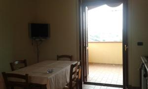 a room with a table and a television and a window at L'Oasi Residence in Istia dʼOmbrone