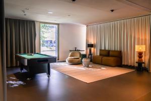 ein Wohnzimmer mit einem Billardtisch und einem Sofa in der Unterkunft Ariv Apartments & Spaces - self check-in in Basel