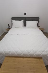 duże białe łóżko z 2 poduszkami w obiekcie K studios w Kalamácie