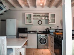 a kitchen with a washing machine and a table at 7 @ The Dunes in Plettenberg Bay