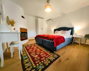 a bedroom with a bed with a red blanket and a fireplace at Portita spre Delta in Jurilovca