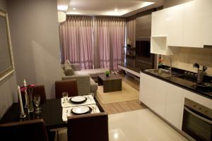 a kitchen and living room with a table and a couch at J Residence Thonglor 8 in Bangkok