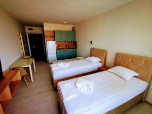 een kleine kamer met 2 bedden en een keuken bij Privately owned Studios Bora Bora in Nesebar