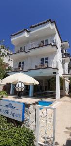 a large white building with an umbrella and a house at Oase Apart in Kalkan