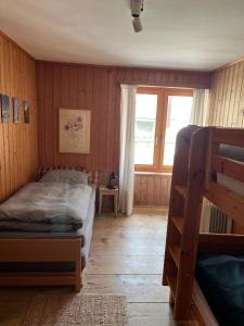 - une chambre avec des lits superposés et une fenêtre dans l'établissement Charisma Peist Act-Sports Arosa, à Peist