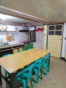 a kitchen with a wooden table and blue chairs at Zeb's Transient House and Tour in Baguio