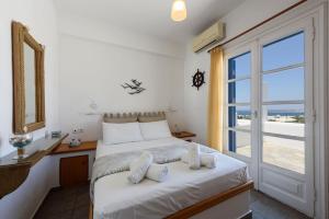 una camera da letto con un letto e una grande finestra di Aigaiou Avra Apartments a Paroikia
