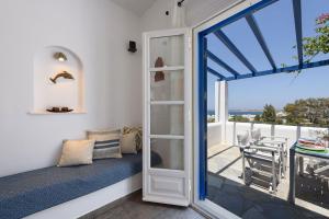 una camera con posto a sedere vicino alla finestra e vista sull'oceano di Aigaiou Avra Apartments a Paroikia