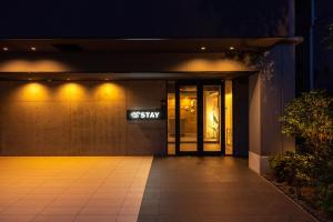 WELLSTAY Osaka Shinimamiya Station في أوساكا: مدخل لمبنى في الليل