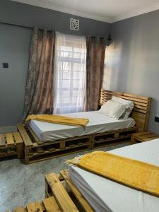 阿魯沙的住宿－Elizabeth Home，一间卧室设有两张床和窗户。