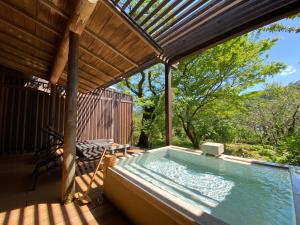 a hot tub on the deck of a house at Kaiseki Ryokan Ashikari in Yugawara