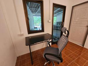 een bureau en een stoel in een kamer met een spiegel bij Village Home, 1br+1lr in Ban Madua Wan