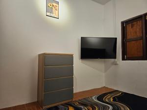um quarto com uma televisão de ecrã plano na parede em Village Home, 1br+1lr em Ban Madua Wan