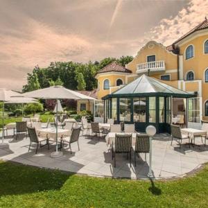 eine Terrasse mit Tischen, Stühlen und einem Pavillon in der Unterkunft Romantikschlössl Loipersdorf Adults Only in Grieselstein