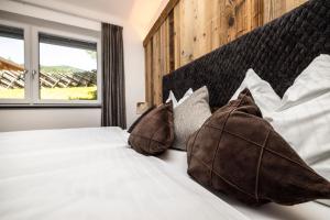 Un dormitorio con una cama blanca con almohadas y una ventana en Landhaus Rustika, en Wagrain