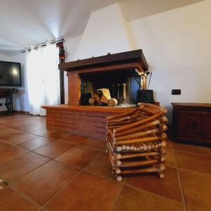 a living room with a brick fireplace with logs at La Rosa dei venti in Calatafimi