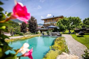a swimming pool in front of a house at Landhaus Rustika in Wagrain