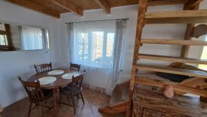 a dining room with a table and chairs and a ladder at Wigierska Buchta (DOMKI) in Rosochaty Róg +11 photos