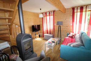 een woonkamer met een blauwe bank en een houtkachel bij Chalet in Gérardmer